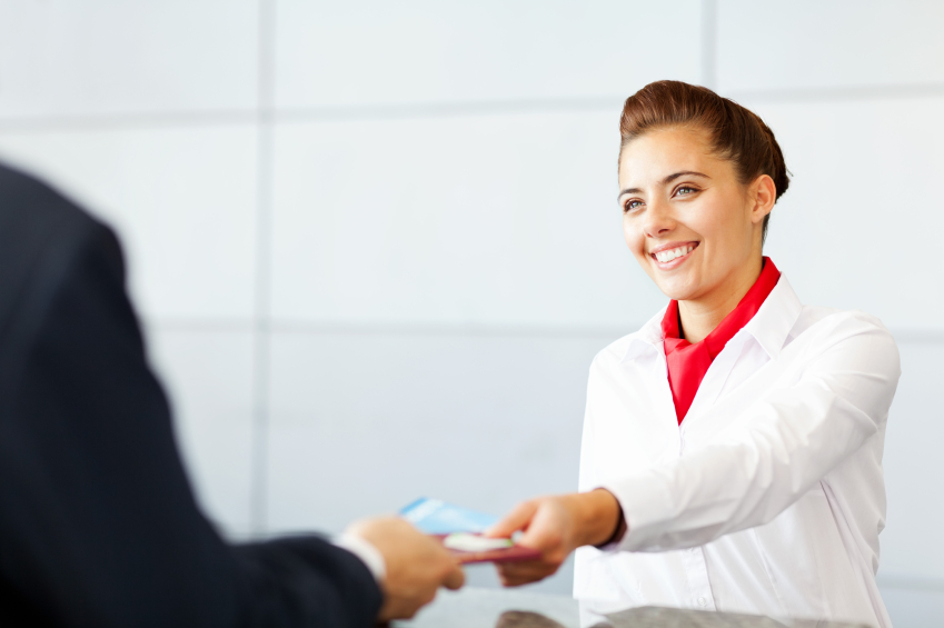 Airline Check In Attendant Handing Tickets To Passenger